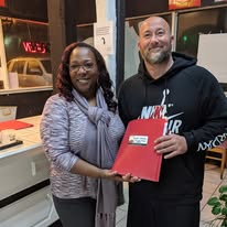Leah Germany handing finished tax paperwork to a returning client